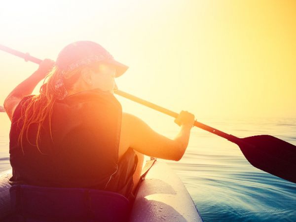 junge Frau im Schlauchboot beim Paddeln